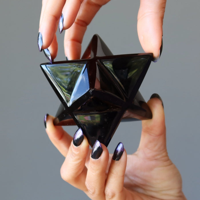 Hands holding Black Obsidian Merkaba