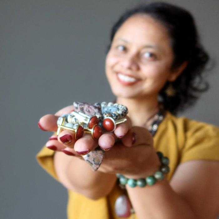 sheila of satin crystals holding out a pile of jewelry
