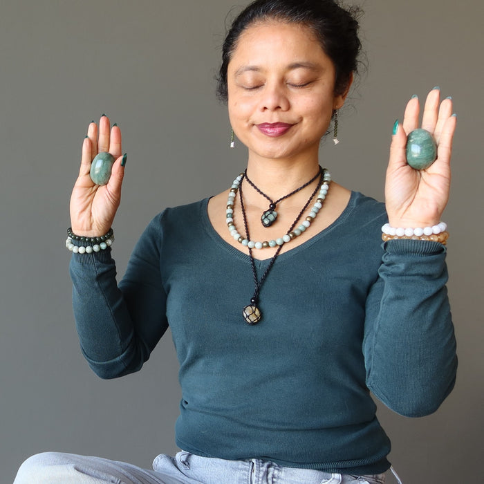 woman meditating with aventurine eggs
