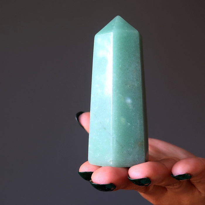 hand balancing a green aventurine tower