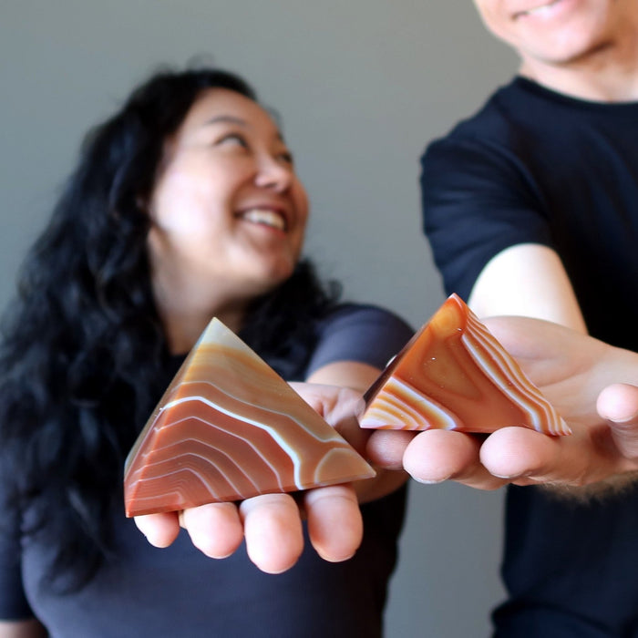 couple holding carnelian pyramids