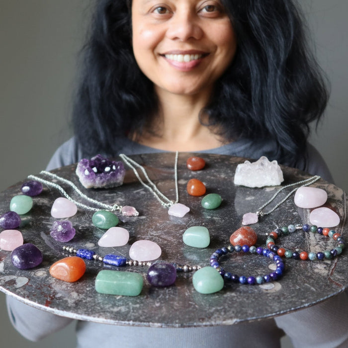 woman holding large fossil platter full of stones and jewelry