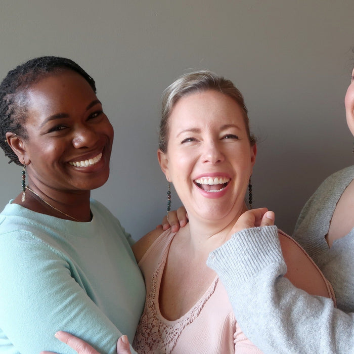 three women wearing bloodstone earrings