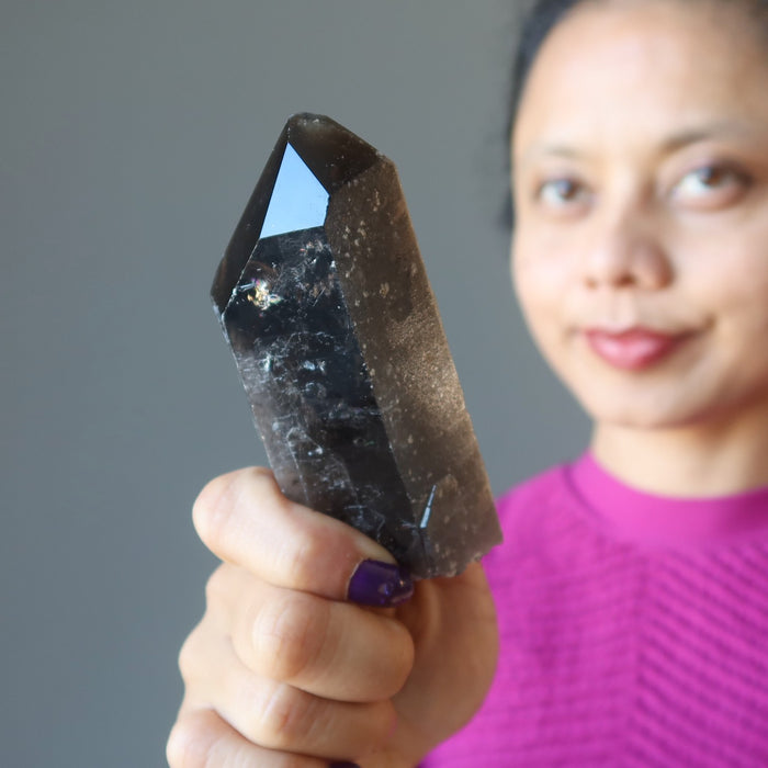 woman holding smoky quartz wand point