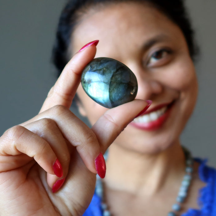 female holding up a labradorite gemstone cabochon