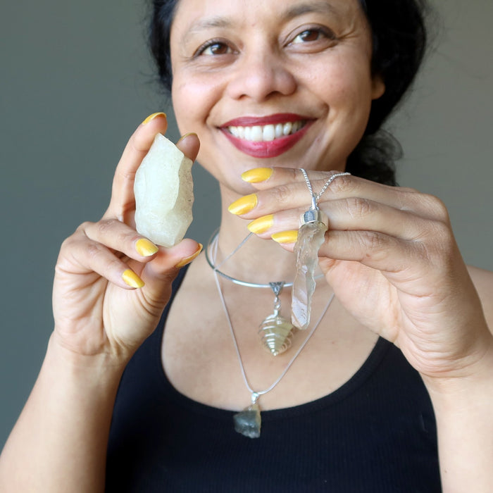 sheila of satin crystals holding and wearing yellow libyan desert glass tektite jewelry and gemstones