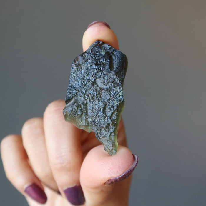hand holding moldavite stone