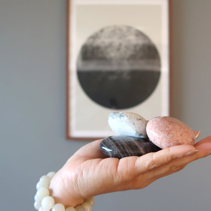hand wearing and holding moonstone crystals