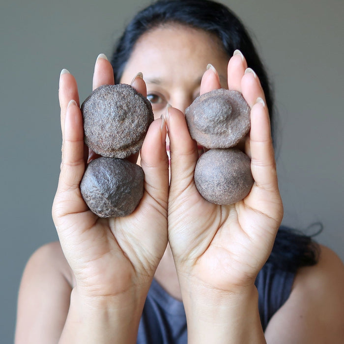 woman holding 4 moqui  marbles