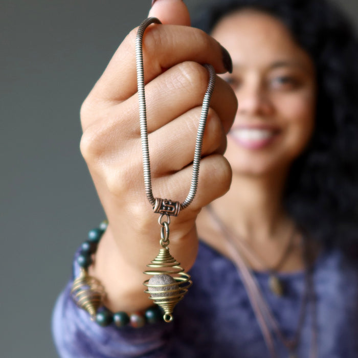sheila of satin crystals holding a moqui marble necklace
