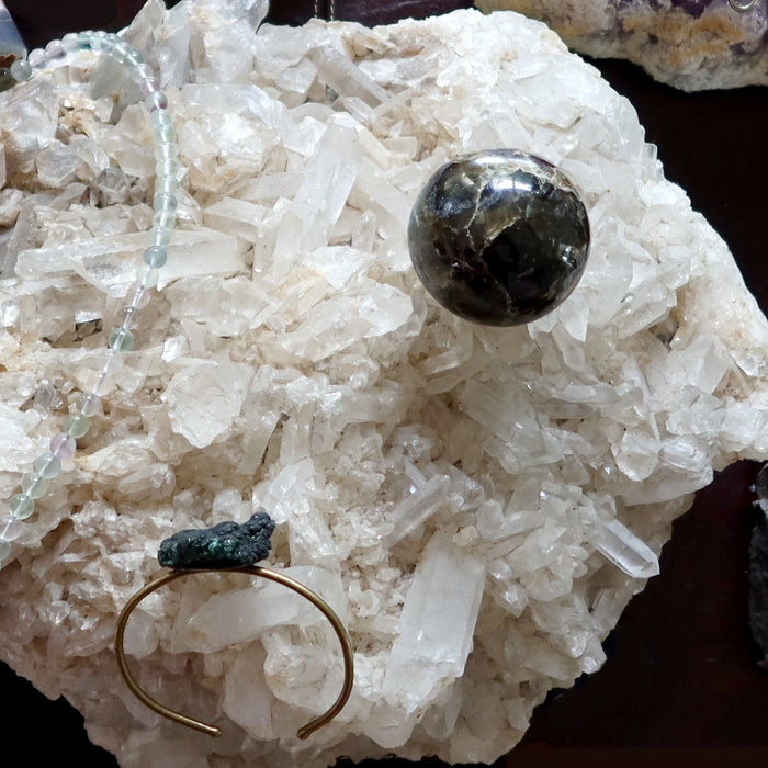 quartz cluster with jewelry and crystal ball on top