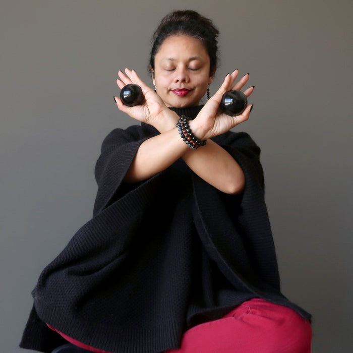 Sheila of Satin Crystals holding two obsidian balls in her hand meditating