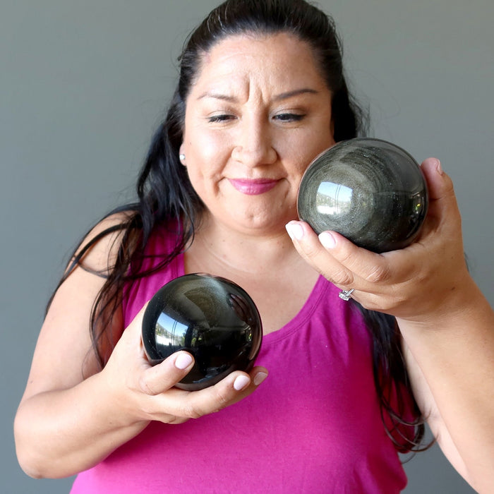 woman holding two obsidian spheres