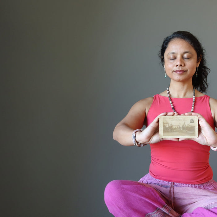 woman meditating with antique postcard