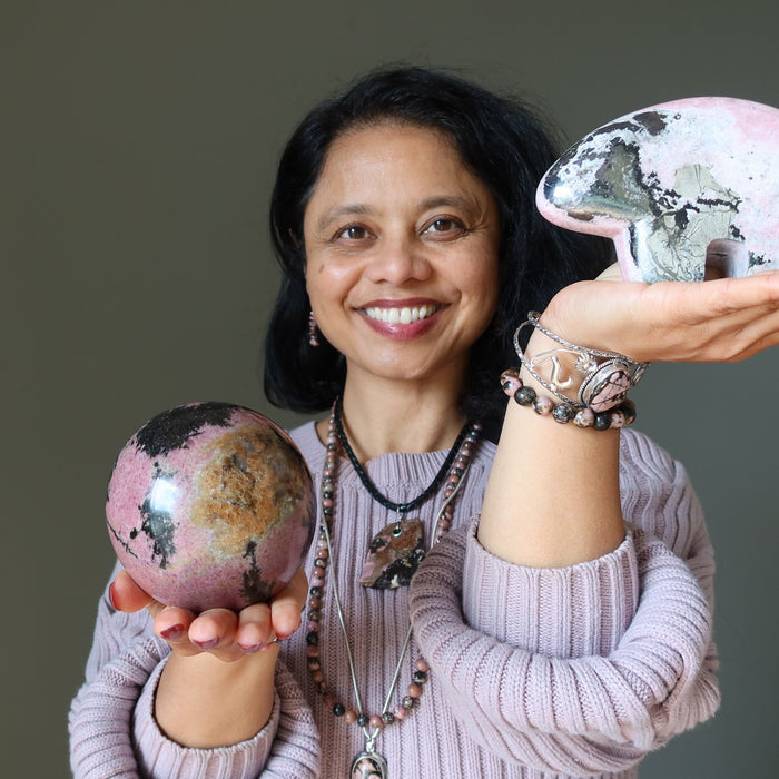 woman holding and wearing rhodonite