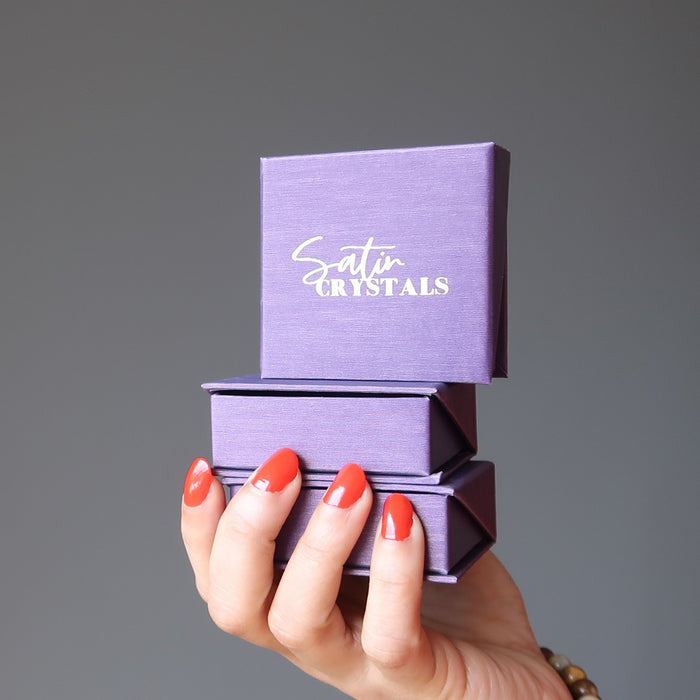 hand holding purple satin crystals jewelry boxes