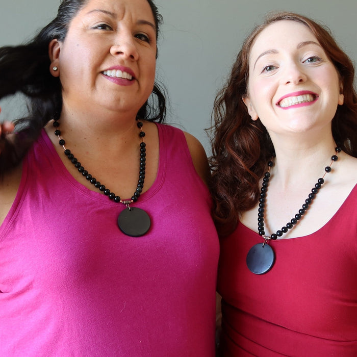 two women wearing shungite necklaces