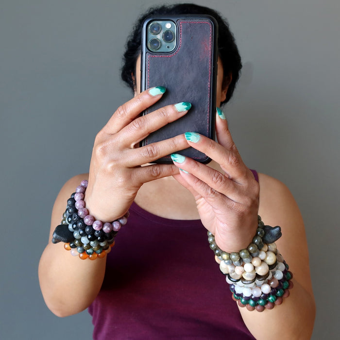 woman wearing a lot of bracelets looking at cell phone