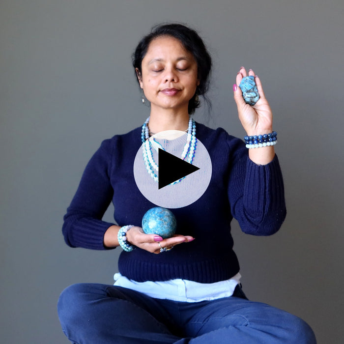 woman meditating with blue stones