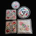 Set of embroidered doilies with floral patterns on a black background
