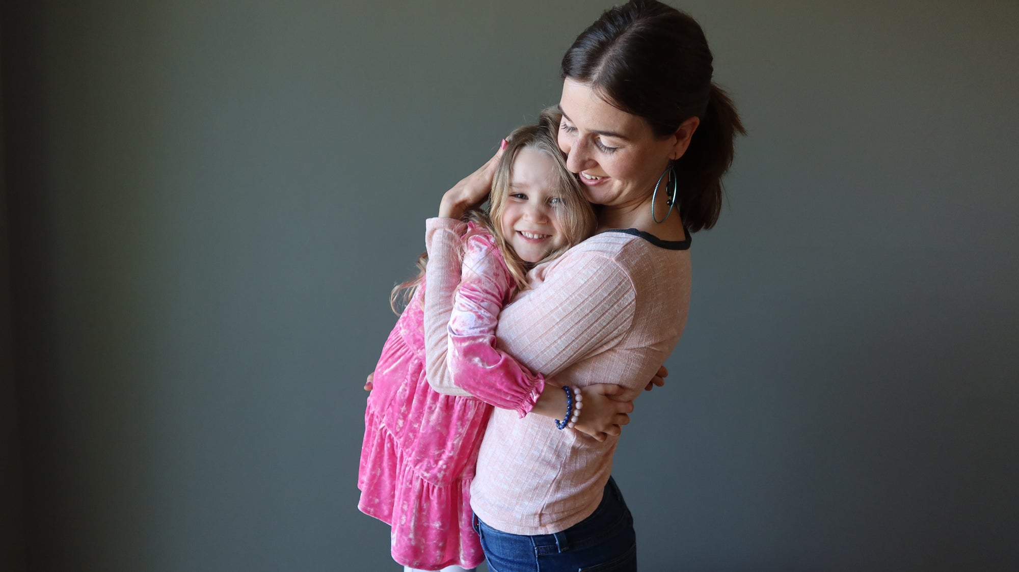 mother and daughter hugging while wearing crystal jewelry