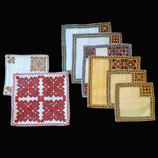 Set of Bereg Hungarian folk art napkin decorative placemats with intricate patterns on a black background