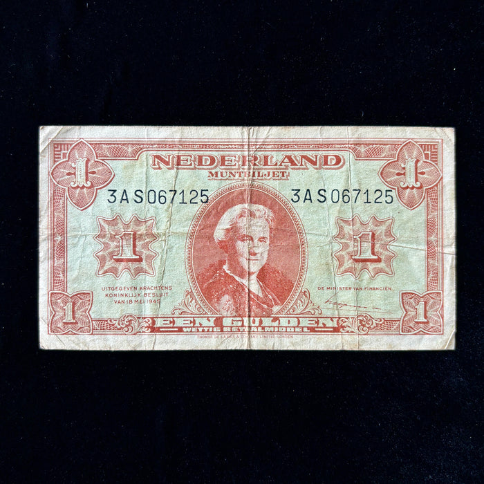 Netherlands old banknote with red and green design on a black background