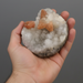 Hand holding quartz and calcite geode