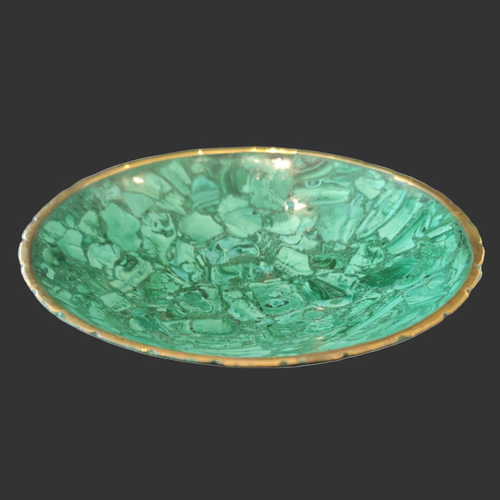Green malachite dish with gold rim on a gray background