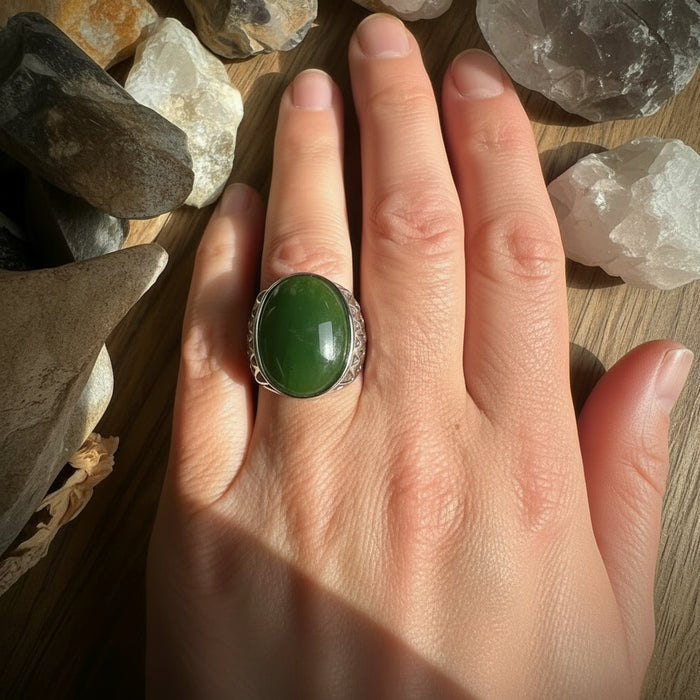 Green jade stone ring on a hand with a natural background