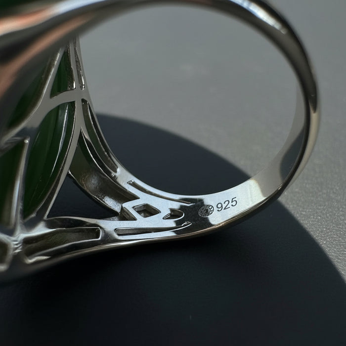 Close-up of a silver ring with '925' stamp on a wooden surface