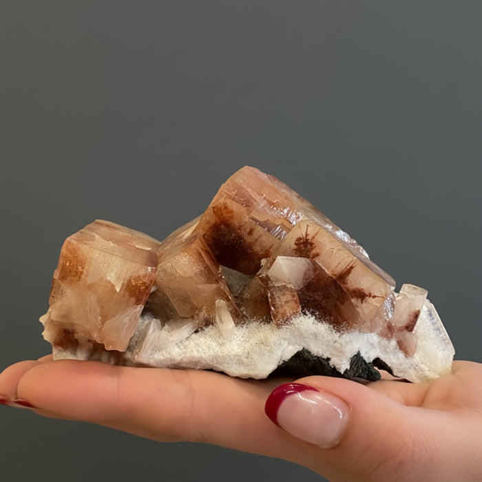 Mineral sample held by a hand with a blurred background