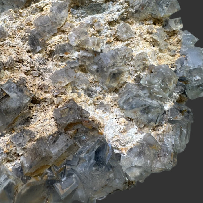 Fluorite mineral sample with crystal formations on a reflective surface