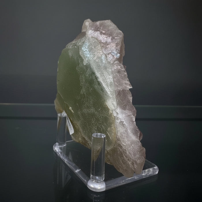 Mineral sample on a clear stand against a reflective surface