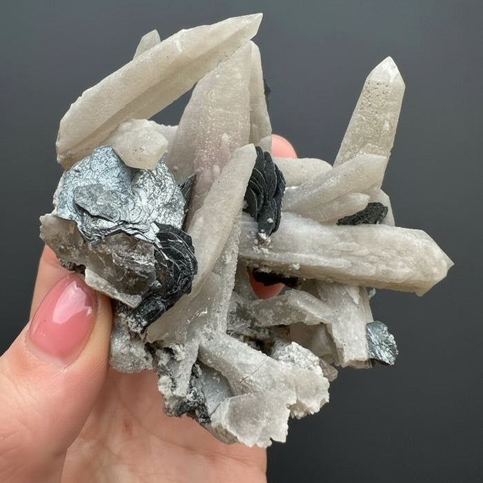 Mineral sample held by a hand with a decorative background