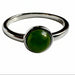 Silver ring with a green gemstone on a white background