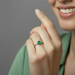 Silver ring with a green gemstone on a white background