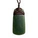Green stone pendant with brown cord on a white background