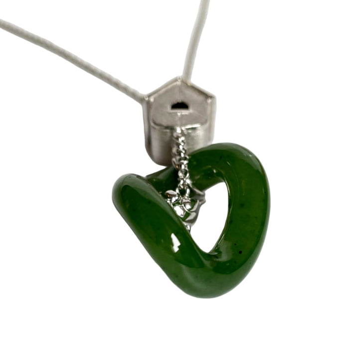 Green heart-shaped pendant on a silver chain against a white background