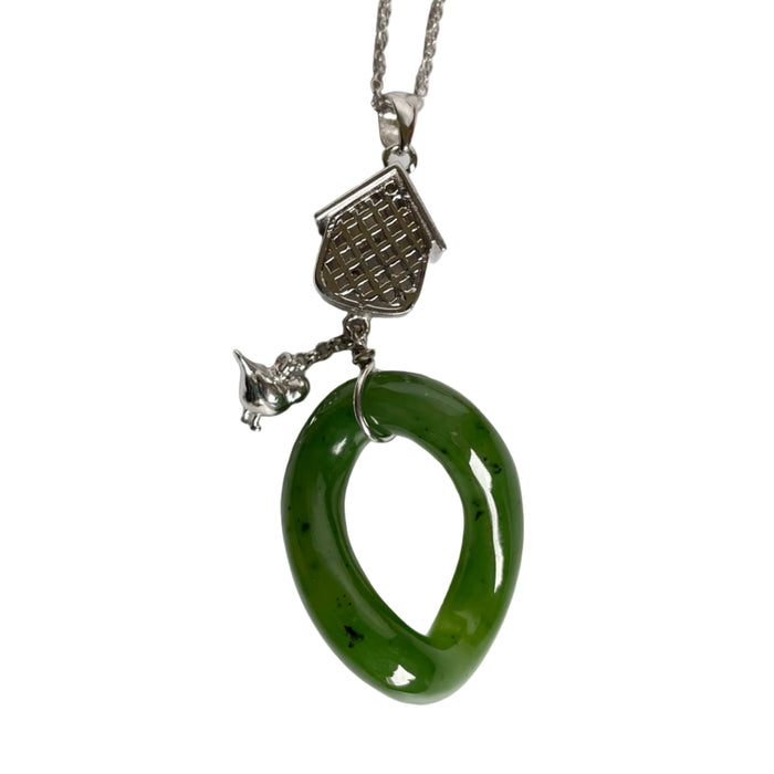 Green jade pendant on a silver chain against a white background