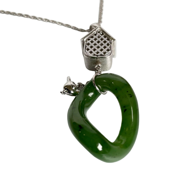 Green jade pendant on a silver chain against a white background