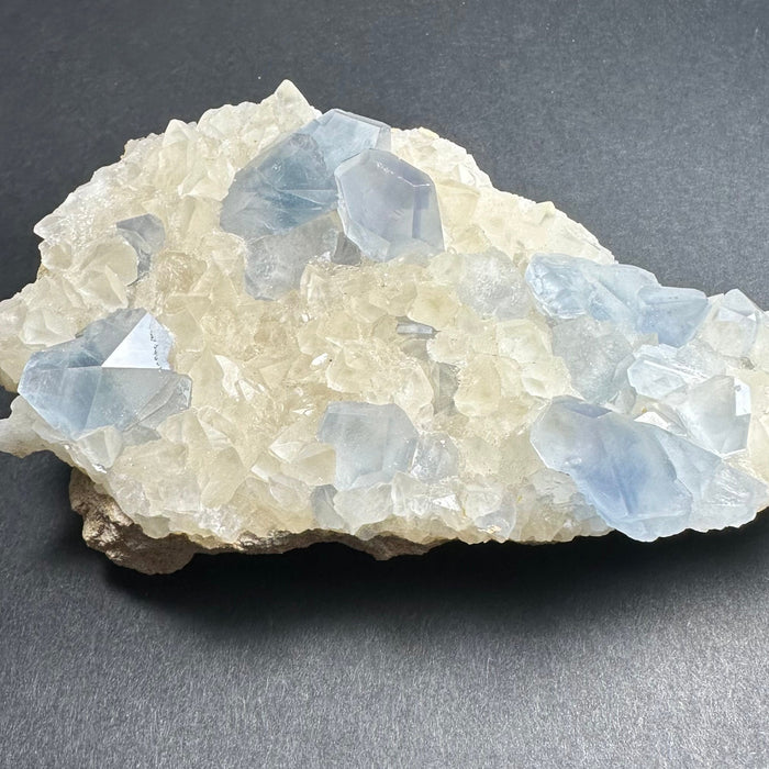 Crystal rock with blue and clear crystals on a dark gray background