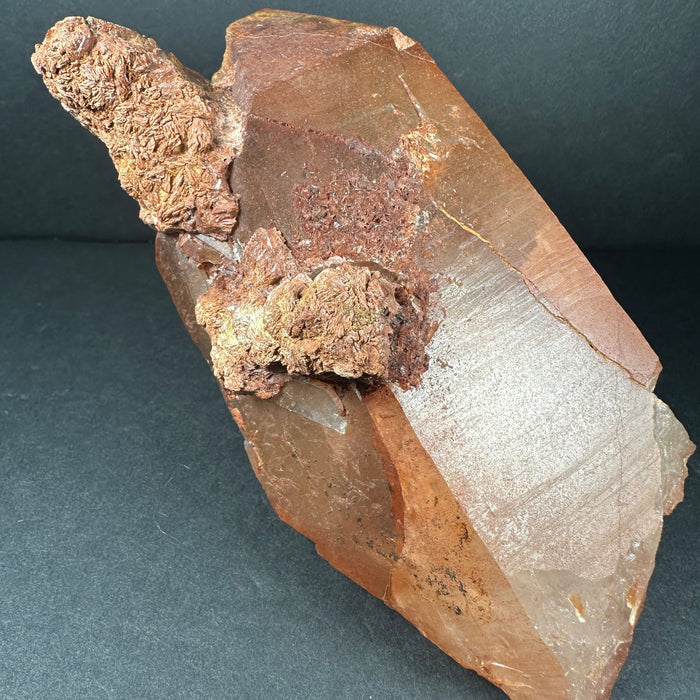 quartz Mineral specimen with brown and clear crystal on a dark gray background