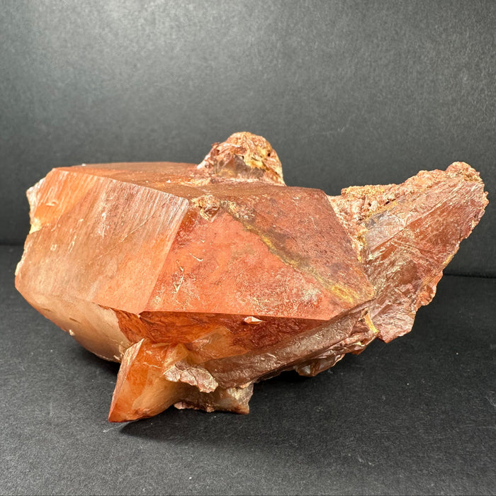 Red-orange quartz crystal on a dark gray background