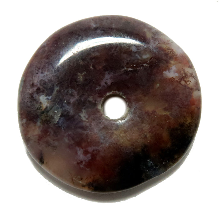 A polished Moss Agate gemstone donut with a red to purple gradient and natural inclusions.