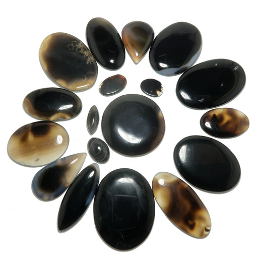 Collection of black and brown stones arranged in a circular pattern on a white background