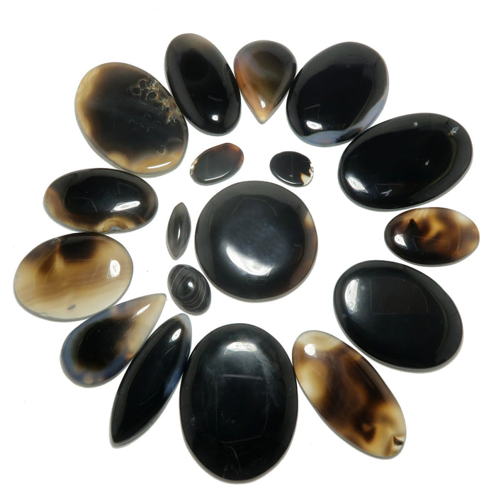 Collection of black and brown stones arranged in a circular pattern on a white background