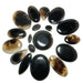 Collection of black and brown stones arranged in a circular pattern on a white background