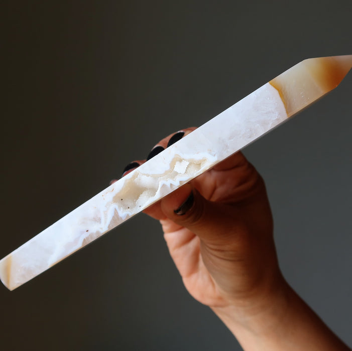 Hand holding a long, thin Agate crystal