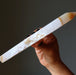 Hand holding a long, thin Agate crystal